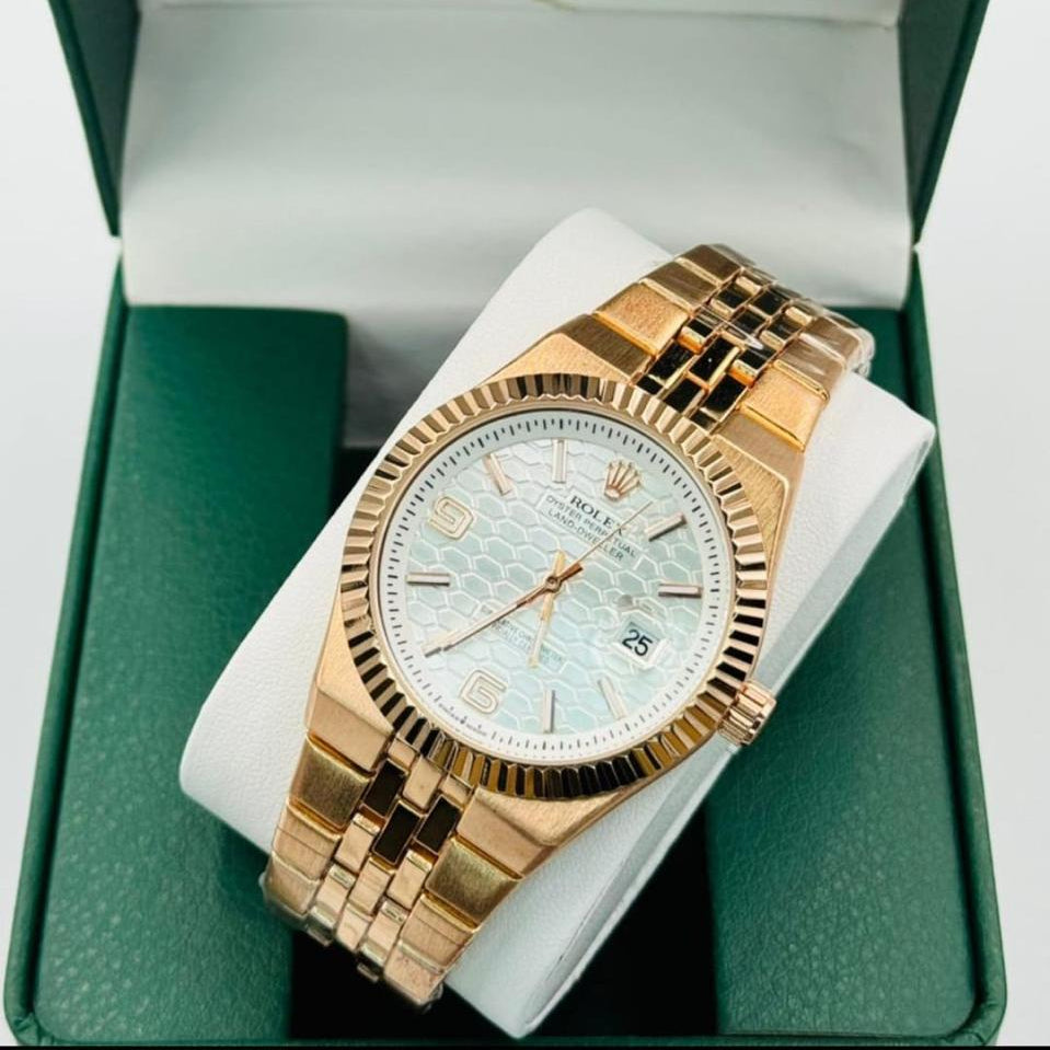 Gold Rolex watch in a green box with the Rolex logo.