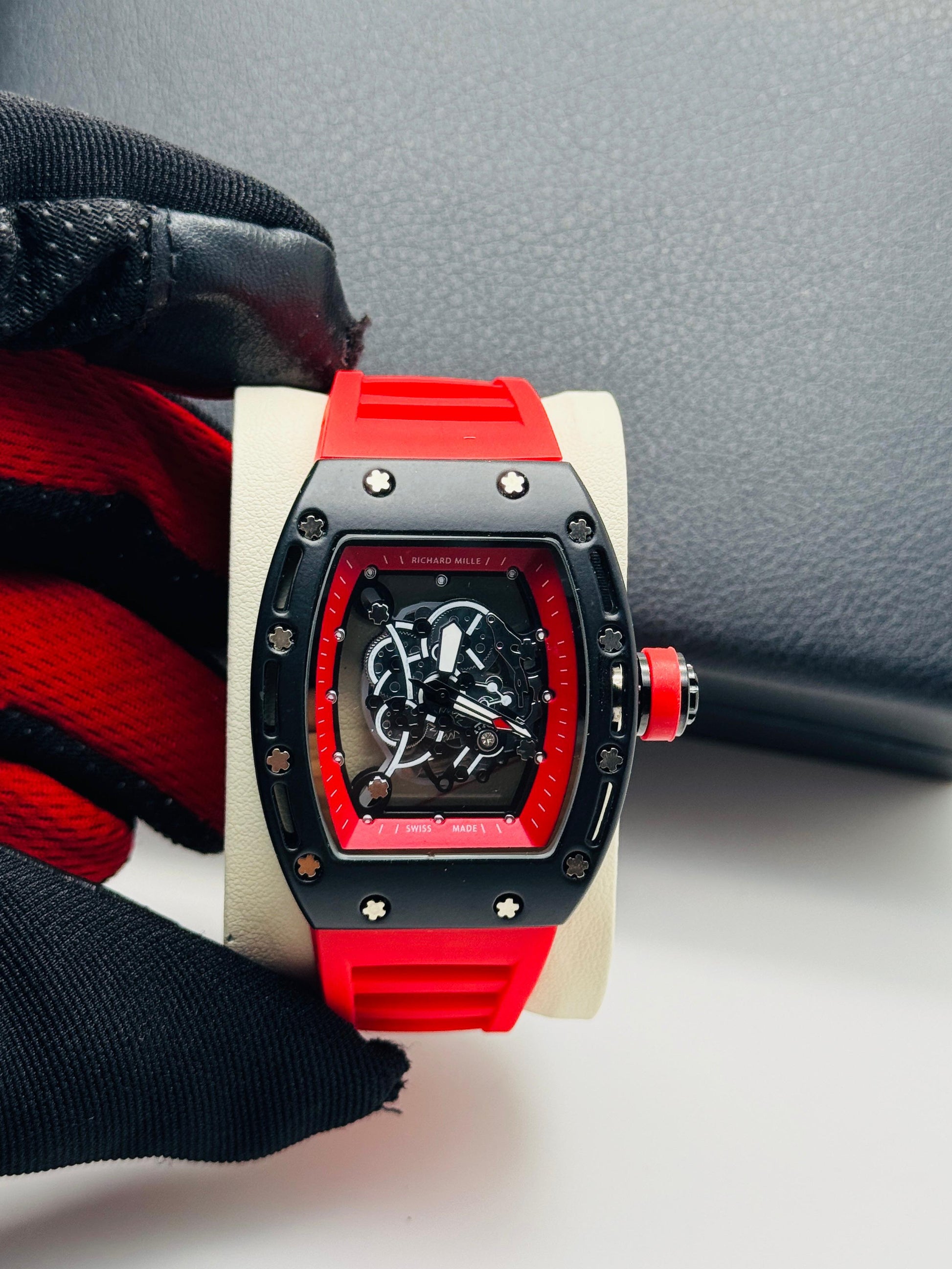 Luxury watch with red and black design on a white surface
