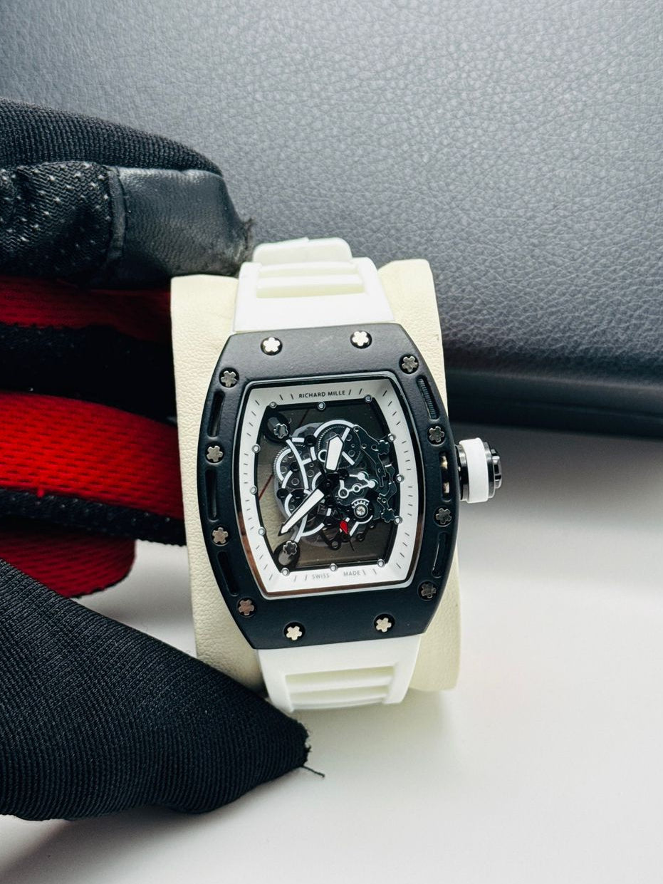 White watch with black face on a white surface, with a black box and red band in the background.