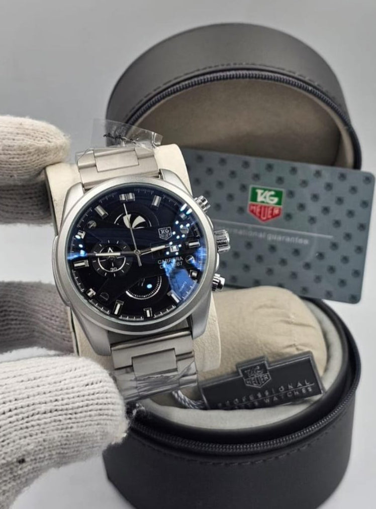 Watch with blue face and silver case in a black display box on a light gray background